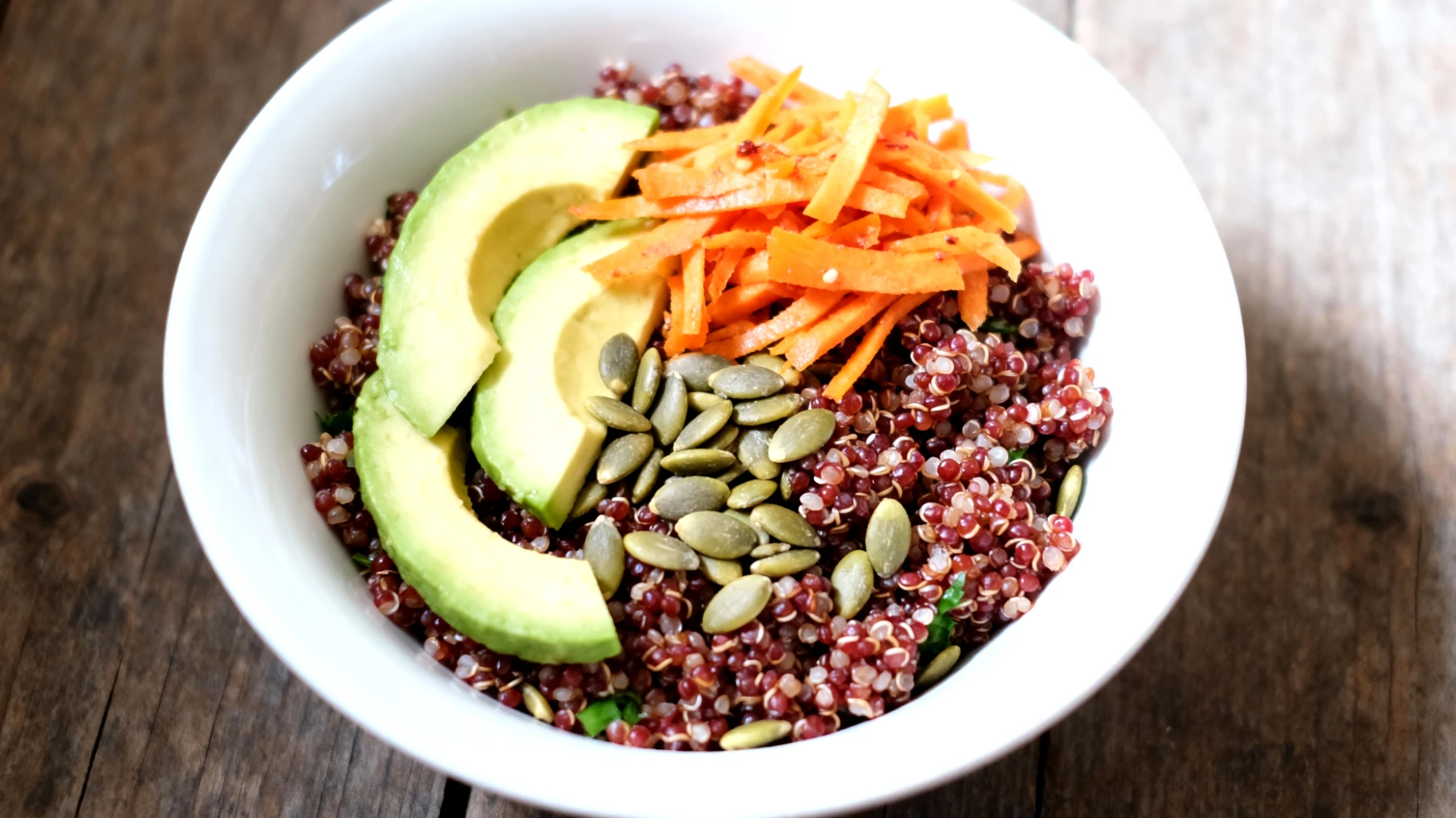 Insalata di quinoa rossa con avocado, semi di zucca e carote fermentate"